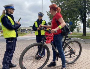 dwie policjantki przy przejsciu dla pieszych i rowerzystka