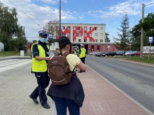 policjantka wręcza maseczkę kobiecie