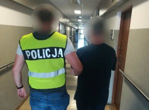 mężczyzna poszukiwany 3 listami gończymi prowadzony przez policjanta