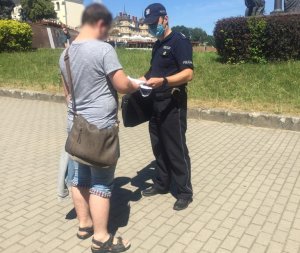 policjant rozdaje mieszkańcom Częstochowy ulotki