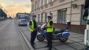 policjanci z ruchu drogowego na alejach stoją przy motocyklach i autobusie kontrolując pojazdy