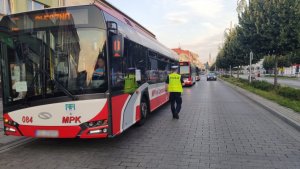 policjanci z ruchu drogowego na alejach stoją przy motocyklach i autobusie kontrolując pojazdy