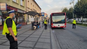 policjanci z ruchu drogowego na alejach stoją przy motocyklach i autobusie kontrolując pojazdy