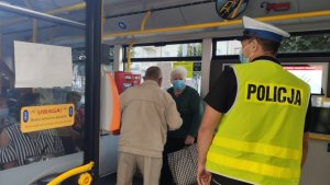 policjant w autobusie kontroluje przestrzeganie obostrzeń