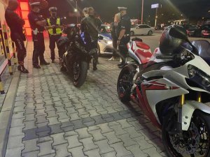 policjanci na parkingu kontrolują dwóch motocyklistów