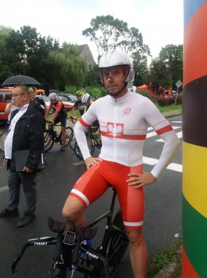 Mistrz Polski - asp. Piotr Ścigała w stroju kolarskim i z rowerem stoi na starcie