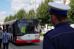 na pierwszym planie tytlem naczelnik ruchu drogowego, w tle autobus, a w kabinie kierowcy policjant w kamizelce odblaskowej sprawdza stan trzeźwości