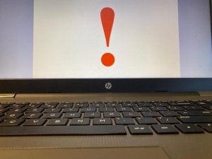 laptop z podniesionym ekranem, na ekranie duży czerwony znak zapytania