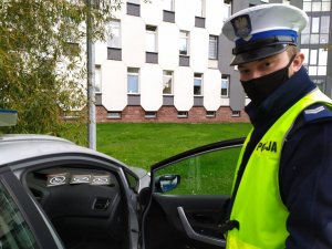 policjant przy radiwozie na podszybiu ulotki