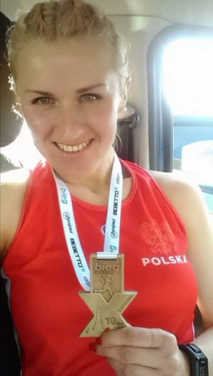 kobieta w aucie, która w ręku trzyma medal