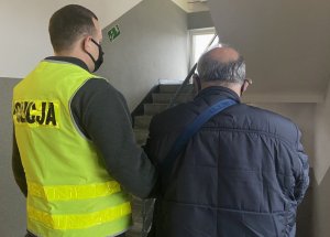 policjant z mężczyzną przy schodach