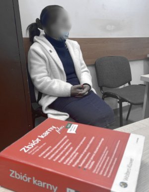 kobieta która siedzi na krzesełku przy ścianie, na pierwszym kodeks karny