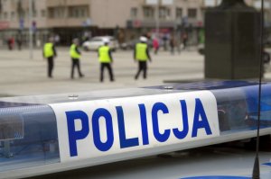 napis policja w tle policjanci ruchu drogowego w kamizelkach odblaskowych idą po Placu Biegańskiego