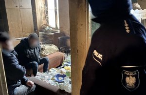 policjant rozmawia z mieszkańcami w lokalu mieszkalnym