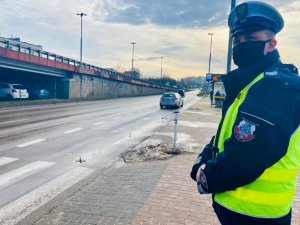 policjant stoi przed przejściem dla pieszych
