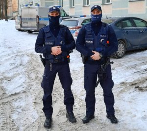 2 umundurowanych policjantów pozuje do zdjęcia stojąc przodem