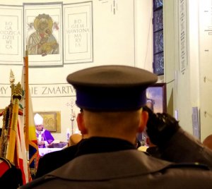 policjant salutuje przed ołtarzem w Kościele