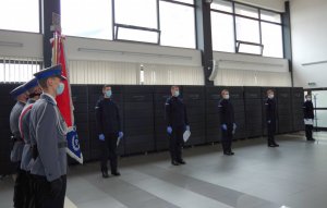 na zdjęciu widać sztandar Komendy Miejskiej Policji w Częstochowie i w tle 5 mianowanych nowo przyjętych policjantów