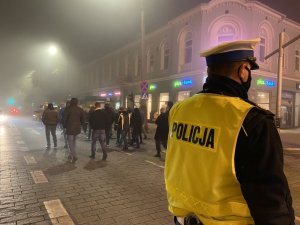 policjant w kamizelce odblaskowej kieruje ruchem przy alei Wolności