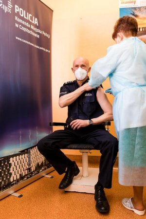 pielęgniarka podaje dawkę szczepionki w ramie panu inspektorowi Dariuszowi Atłąsikowi
