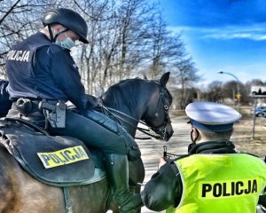 policjant z ruchu drogowego pokazuje odczyt z radaru policjantowi siedzącemu na koniu