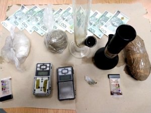 narkotyki rozłożone na biurku, obok leżą banknoty każdy po 100 złotych