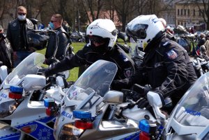 2 policjantów siedzi na motocyklach i rozmawia ze sobą
