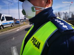 policjant w maseczce stoi przy drodze - zbliżenie na jego twarz