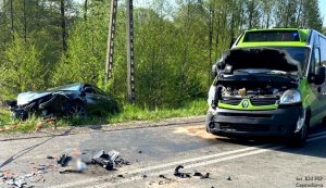 wypadek drogowy z udziałem busa i mazdy - mazda w rowie , bus z uszkodzonym przodem samochodu stoi na drodze