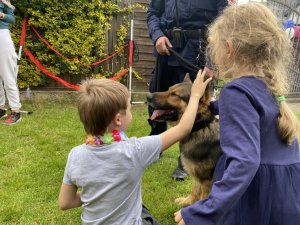 dzieci głaskają psa służbowego