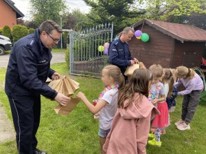 Naczelnik i przewodnik psa rozdają dzieciom prezenty