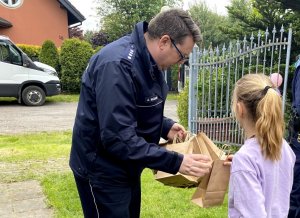 Naczelnik i przewodnik psa rozdają dzieciom prezenty