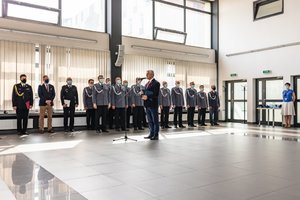 przemówienie burmisztrza powiatu częstochowskiego na tle stojacych w szeregu oficerów Policji i gości