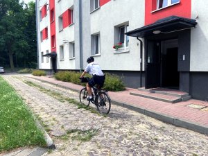 policjant na rowerze patroluje swój rejon służbowy - osiedle mieszkaniowe