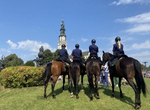 4 policjantów na koniach służbowych stoi na jasnogórskich błoniach