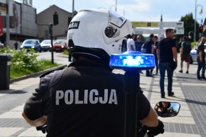 policjant na motocyklu tyłem do fotografującego