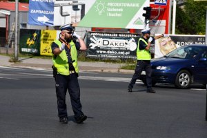 policjanci z odblaskowych kamizelkach na skrzyżowaniu kierują ruchem