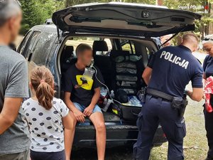 policjant podaje tlen chłopakowi siedzącemu w samochodzie