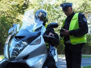 policjant sprawdza stan licznika w motocyklu