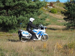 policjant na motocyklu zjeżdża zieleńca