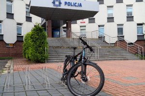 rower przypięty do stojaka, w tle budynek Komendy Miejskiej Policji w Częstochowie