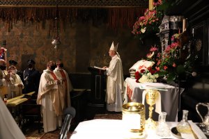 Arcybiskup podczas celebrowania mszy, przed nim widać stojących paulinów