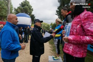 3 kobiety stoją na podium. Zastępca Komendanta Wojewódzkiego gratuluje policjantce z Częstochowy stojącej na podium