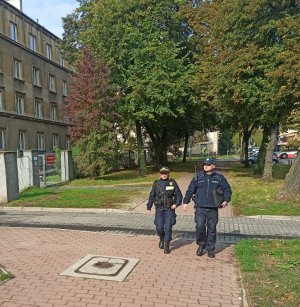 Strażniczka miejska oraz policjant patrolują ulice przy szkole