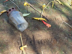 potłuczony szklany znicz na płycie nagrobkowej na cmentarzu w Kisielinie