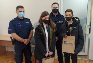 dwóch policjantów stoi z uczniem i uczennicą - zwycięzcami konkursów