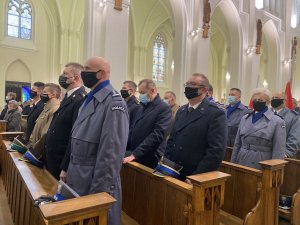 policjanci i przedstawiciele innych służb mundurowych stoją podczas mszy w Bazylice Archikatedralnej Świętej Rodziny