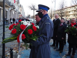 inspektor Dariusz Atłasik Komendant Miejski Policji w Częstochowie trzyma wieniec kwiatów przed położeniem go przy tablicy pamiątkowej
