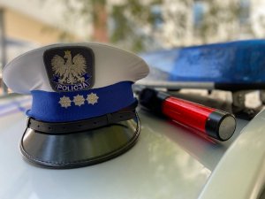 czapka z białym pokrowcem i urządzenie do badania trzeźwości leżą na dachu radiowozu policyjnego