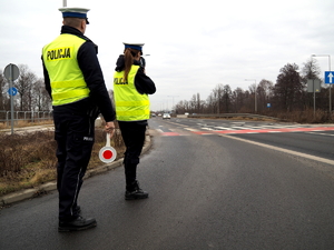 policjantka z ręcznym miernikiem prędkości mierzy prędkość samochodów przy przejściu dla pieszych